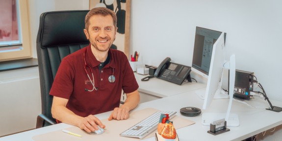 Hr. Bice am Schreibtisch lächelt