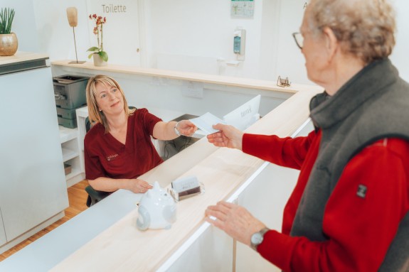 Fr. Aumüller überreicht eine Verschreibung an einen Patienten