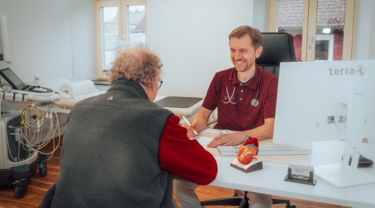 Dr. Bice lacht mit einem Kunden während einem Arztgespräch