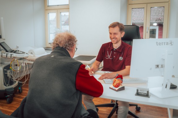 Dr. Bice lacht mit einem Kunden während einem Arztgespräch